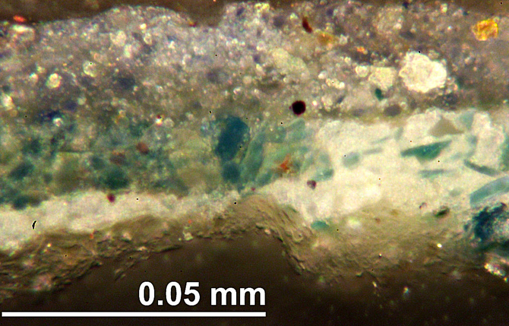 A cross section under magnification showing the pigment layer structure with shards of brilliant original azurite